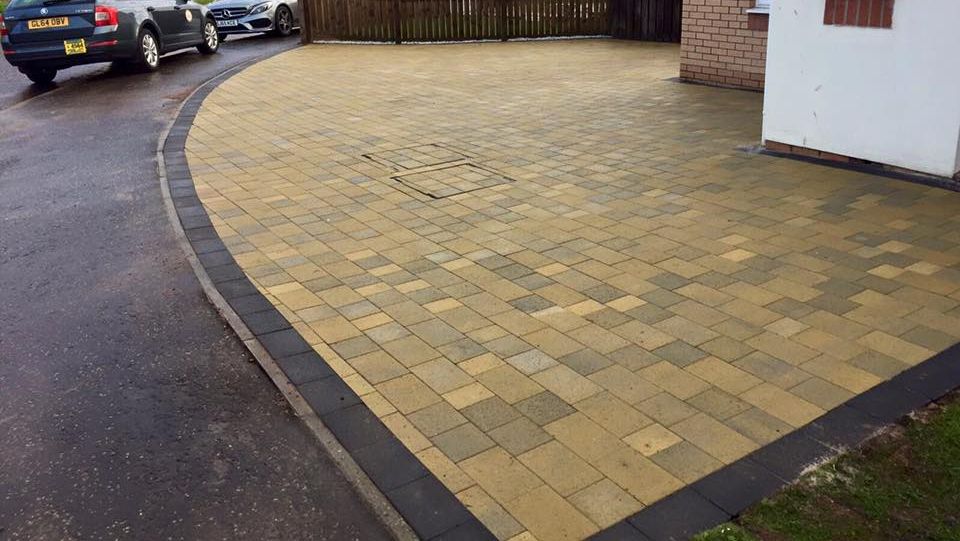 Sunflower Maura paved driveway with charcoal border and rainbow sawn sandstone patio.