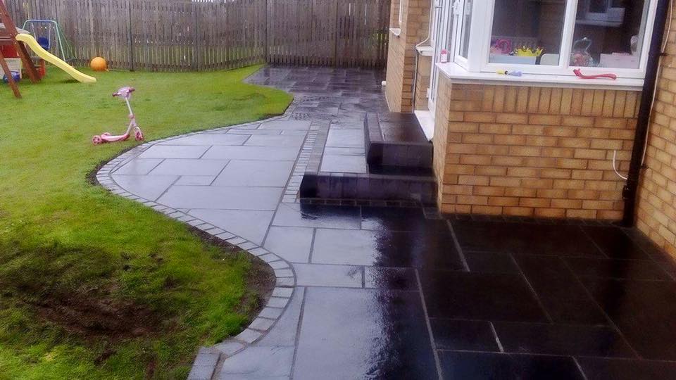 Black limestone with black cobble border split into two levels with two new large sets of steps.