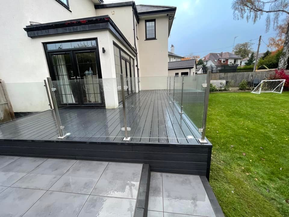 Indie paving & R M Joinery collaboration with this garden makeover installing a large composite deck with glass balustrade, porcelain patio and steps